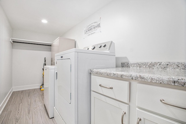 6927 Drumlin Dr, Zeeland, MI 49464 - laundry area with separate washer and dryer, light wood-type flooring, baseboards, and cabinet space