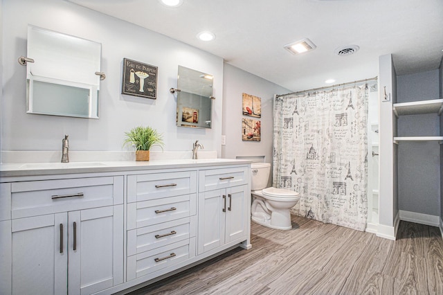 6927 Drumlin Dr, Zeeland, MI 49464 - full bath featuring wood finished floors, toilet, double vanity, curtained shower, and recessed lighting