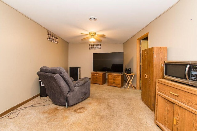 living room featuring light colored carpet, a ceiling fan, and baseboards