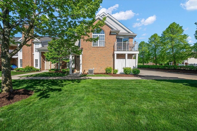 view of front of home featuring central air condition unit, brick siding, a front lawn, and a balcony