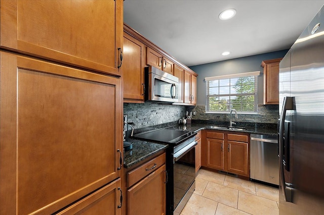 kitchen with stainless steel appliances, a sink, backsplash, light tile patterned floors, and recessed lighting