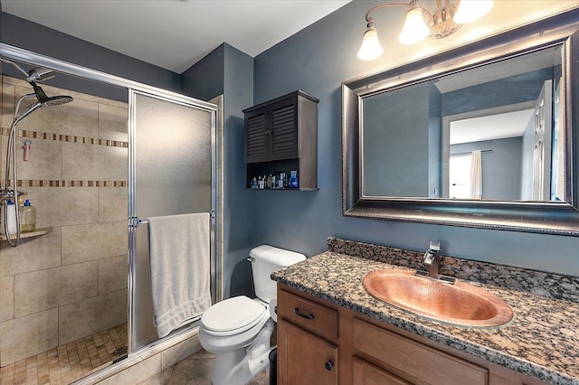 bathroom featuring a shower stall, vanity, and toilet