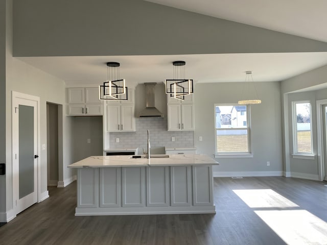 kitchen with wall chimney exhaust hood, a sink, dark wood-style floors, backsplash, and white cabinets