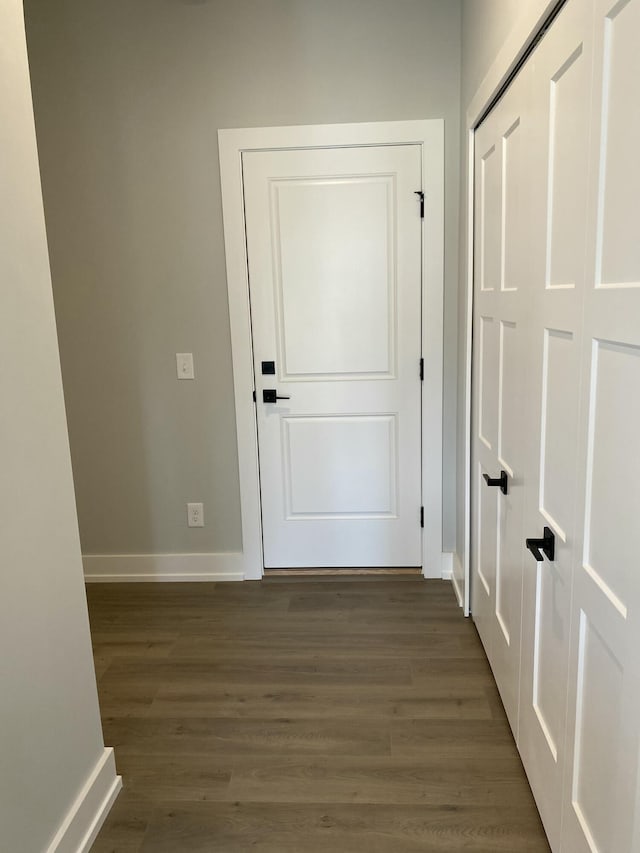 doorway with baseboards and dark wood finished floors
