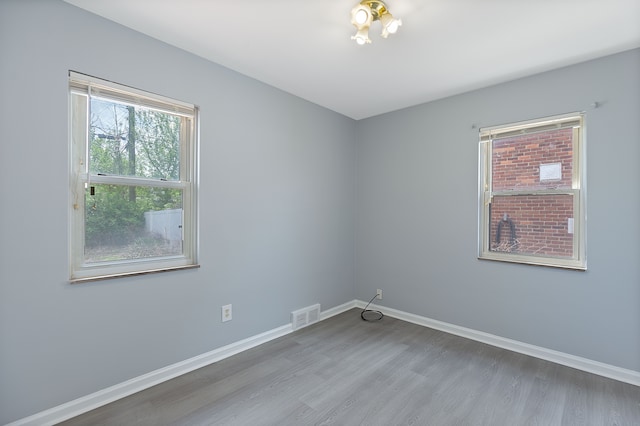 spare room with wood finished floors and baseboards