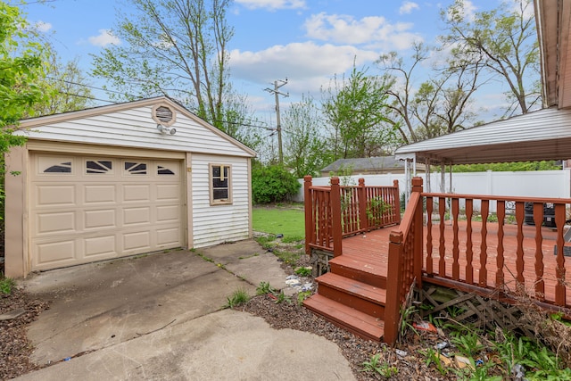 detached garage featuring driveway and fence
