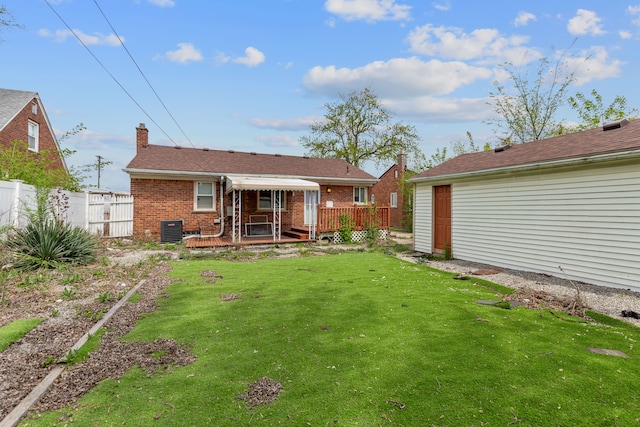 back of house featuring brick siding, a deck, cooling unit, and a chimney