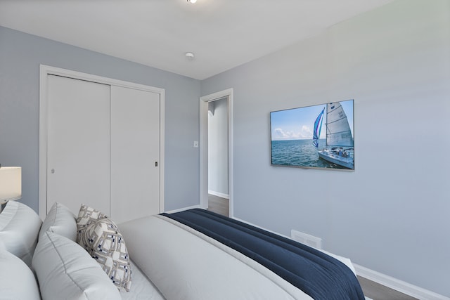 bedroom with baseboards, a closet, and wood finished floors