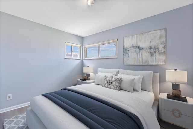 bedroom featuring wood finished floors and baseboards