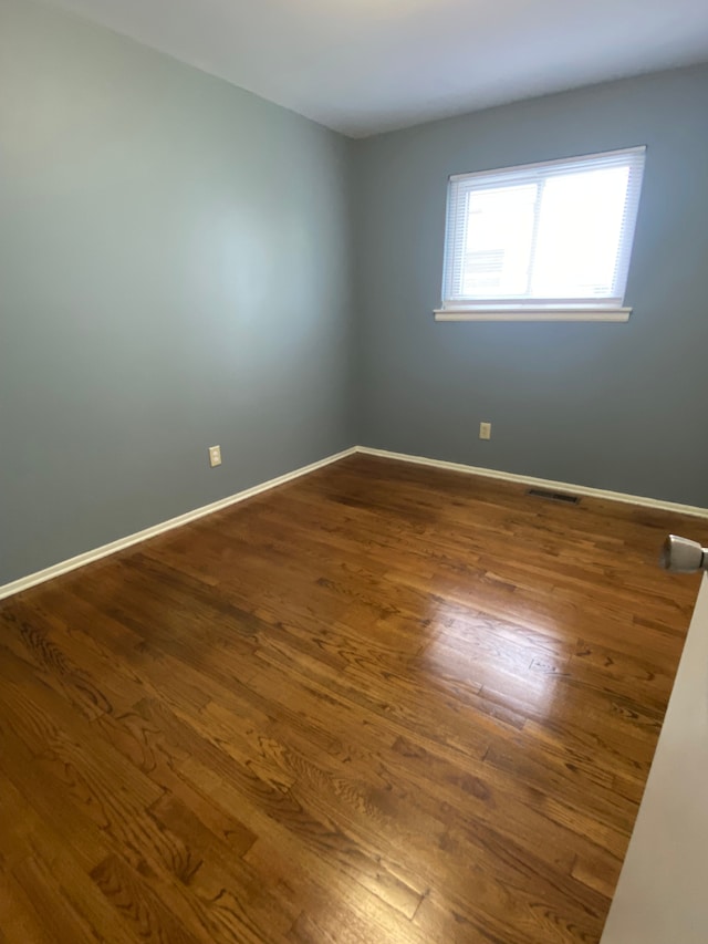 657 Highland Ave, Lincoln Park, MI 48146 - spare room featuring dark wood-style flooring and baseboards