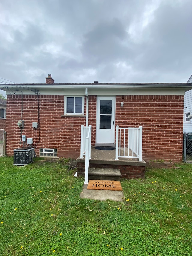 657 Highland Ave, Lincoln Park, MI 48146 - back of house with brick siding, a chimney, and cooling unit