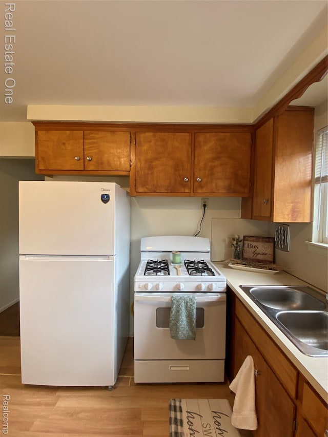 657 Highland Ave, Lincoln Park, MI 48146 - kitchen with white appliances, a sink, and brown cabinetry