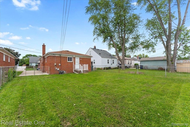 657 Highland Ave, Lincoln Park, MI 48146 - back of house with brick siding, a fenced backyard, and a chimney