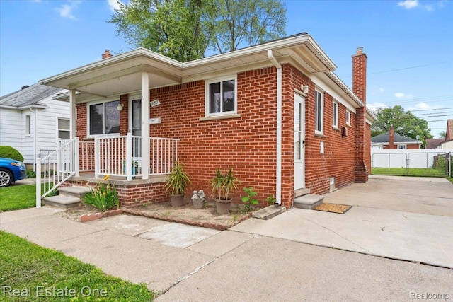 657 Highland Ave, Lincoln Park, MI 48146 - view of front facade with a chimney, brick siding, and driveway
