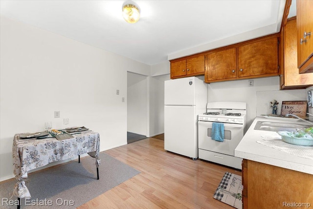 657 Highland Ave, Lincoln Park, MI 48146 - kitchen featuring white appliances, brown cabinetry, light wood-style flooring, and light countertops