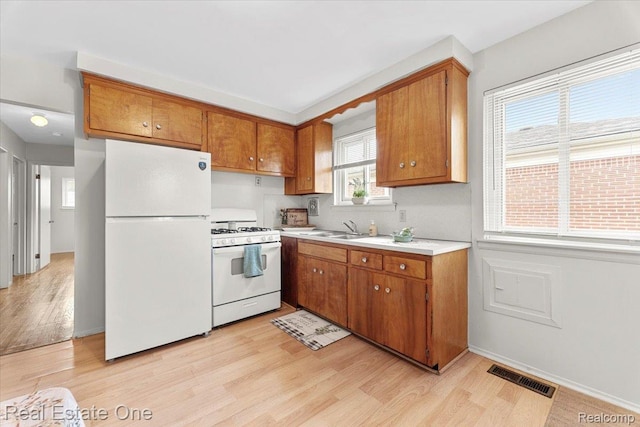 657 Highland Ave, Lincoln Park, MI 48146 - kitchen with white appliances, brown cabinets, light wood-type flooring, and light countertops