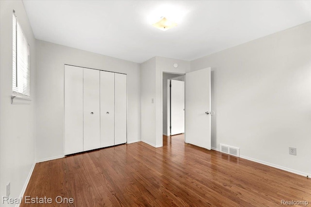 657 Highland Ave, Lincoln Park, MI 48146 - unfurnished bedroom with wood finished floors and a closet