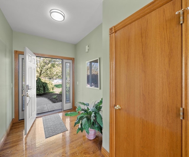 entryway with light wood finished floors and baseboards