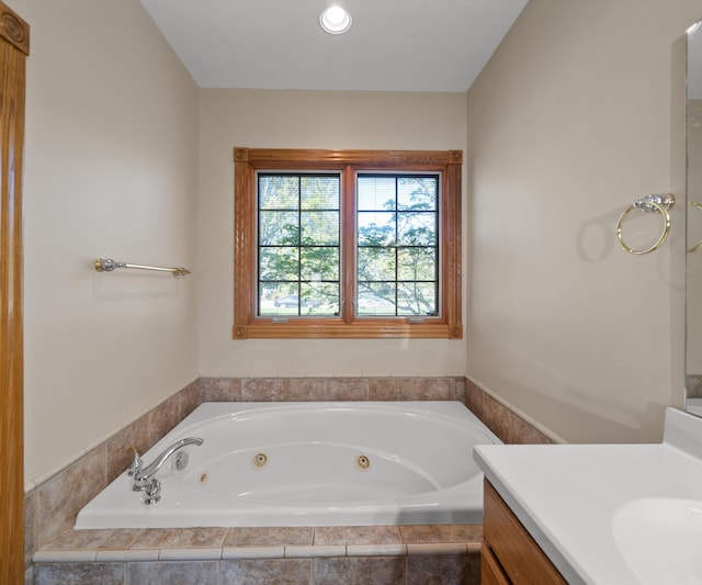 full bath featuring vanity and a whirlpool tub