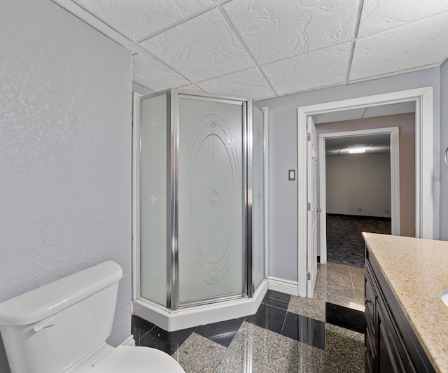 full bathroom featuring granite tiled floors, a stall shower, toilet, and vanity