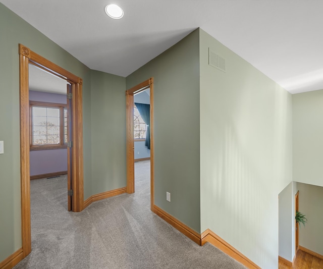 corridor featuring plenty of natural light, baseboards, and carpet floors