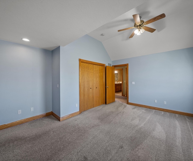 unfurnished bedroom with baseboards, vaulted ceiling, carpet, a closet, and recessed lighting