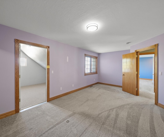 carpeted empty room with baseboards