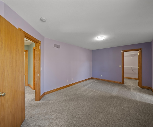 carpeted empty room with baseboards and a smoke detector