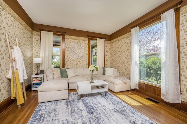 210 E St, Three Rivers, MI 49093 - living room featuring wood finished floors, wallpapered walls, plenty of natural light, and baseboards