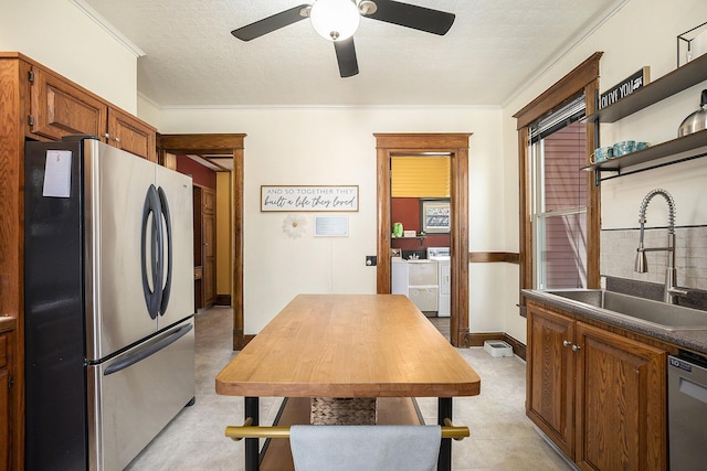 210 E St, Three Rivers, MI 49093 - kitchen featuring stainless steel appliances, a sink, a ceiling fan, separate washer and dryer, and open shelves