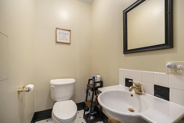 210 E St, Three Rivers, MI 49093 - half bathroom featuring toilet, baseboards, and a sink
