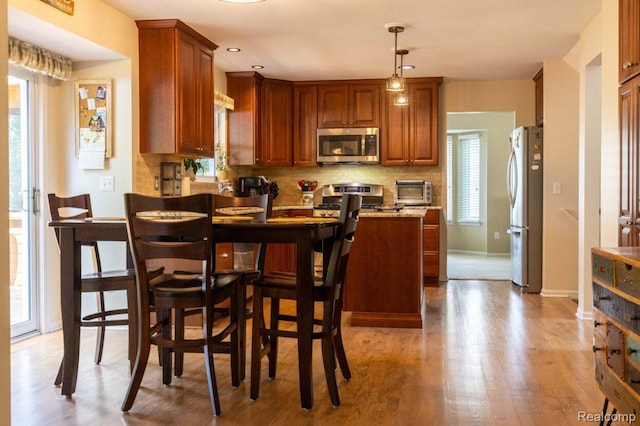 3163 W Ridge Ct, Commerce Twp, MI 48390 - kitchen with stainless steel appliances, a peninsula, tasteful backsplash, light wood-style flooring, and recessed lighting