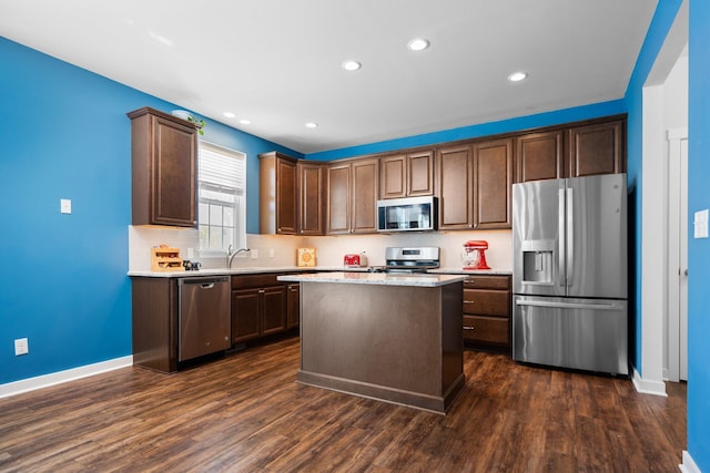 kitchen featuring appliances with stainless steel finishes, dark wood-style flooring, baseboards, decorative backsplash, and recessed lighting