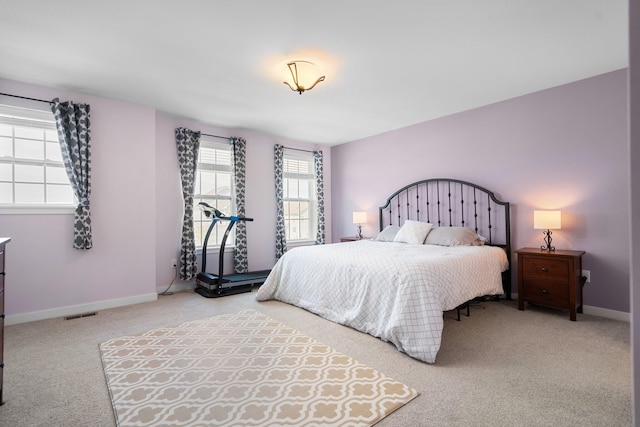 bedroom with light colored carpet and baseboards