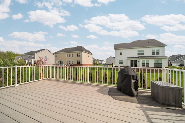 wooden terrace with a residential view and a grill