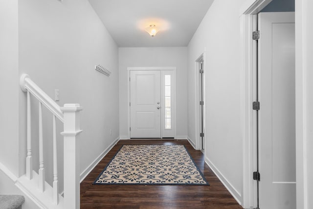 foyer entrance with dark wood-type flooring and baseboards