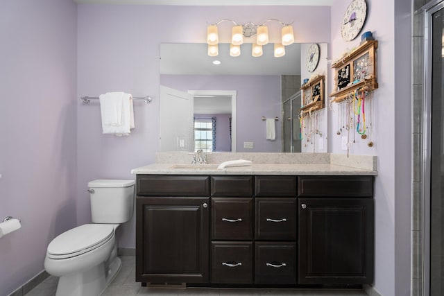 bathroom with toilet, baseboards, tile patterned flooring, vanity, and a shower