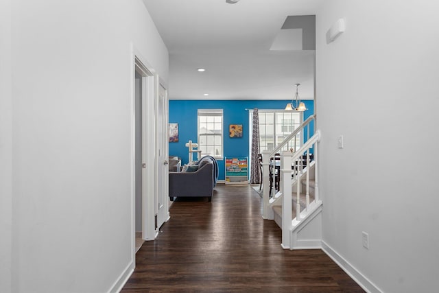 hallway with baseboards, wood finished floors, a chandelier, stairway, and recessed lighting