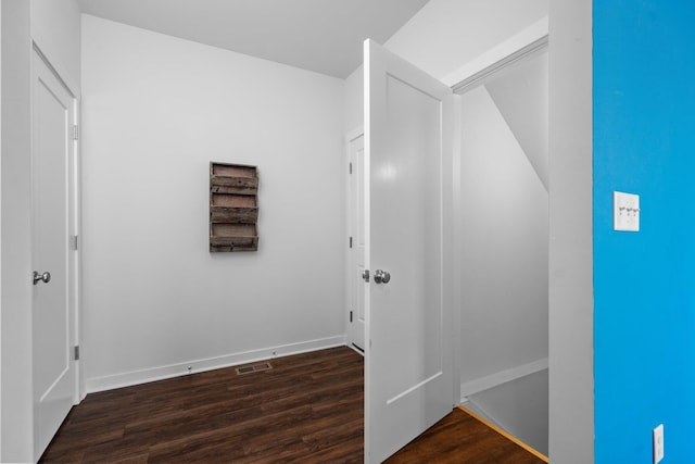 hallway featuring dark wood finished floors and baseboards