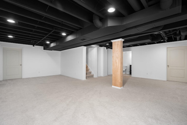 finished basement featuring stairs and carpet