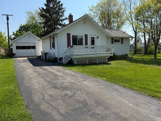 27 Turrill Ave, Lapeer, MI 48446 - view of front facade featuring an outbuilding, a garage, a chimney, asphalt driveway, and a front lawn