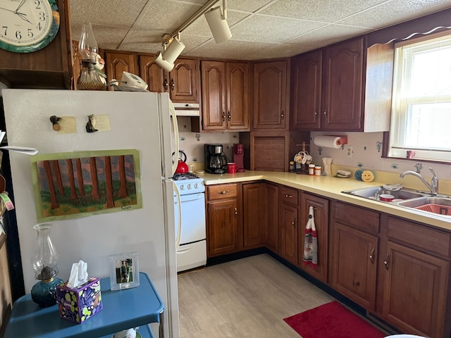 27 Turrill Ave, Lapeer, MI 48446 - kitchen with white appliances, under cabinet range hood, a sink, light countertops, and a paneled ceiling