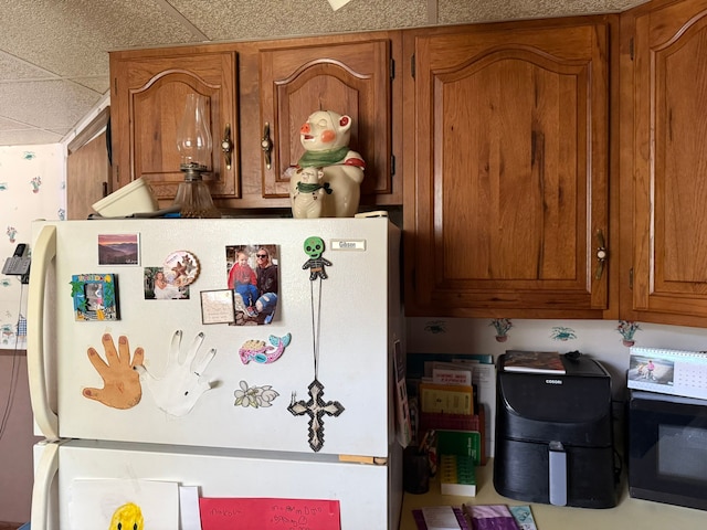 27 Turrill Ave, Lapeer, MI 48446 - kitchen featuring freestanding refrigerator and brown cabinetry