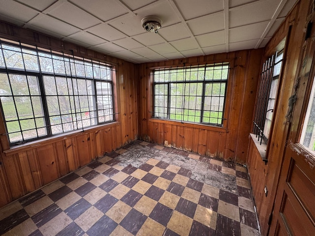 spare room featuring tile patterned floors and wood walls