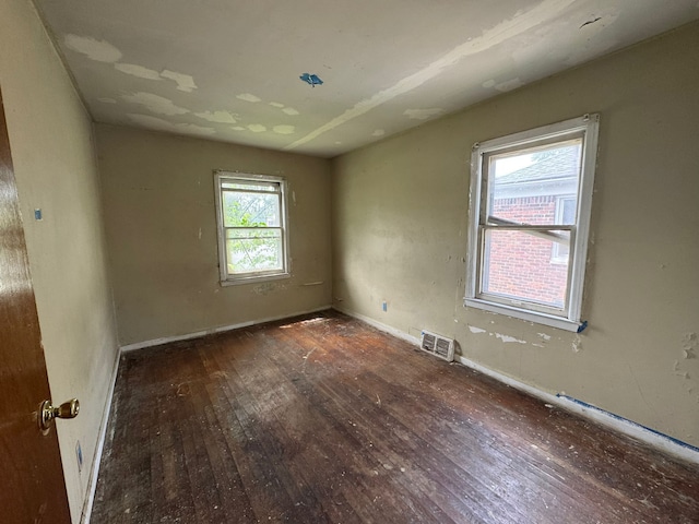 empty room with hardwood / wood-style flooring and baseboards