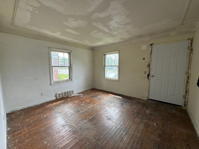 empty room featuring hardwood / wood-style floors, healthy amount of natural light, and baseboards