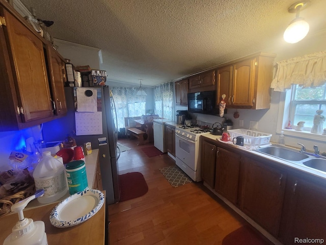 3092 Durant Hts, Grand Blanc, MI 48507 - kitchen with black microwave, white gas range, a textured ceiling, plenty of natural light, and a sink