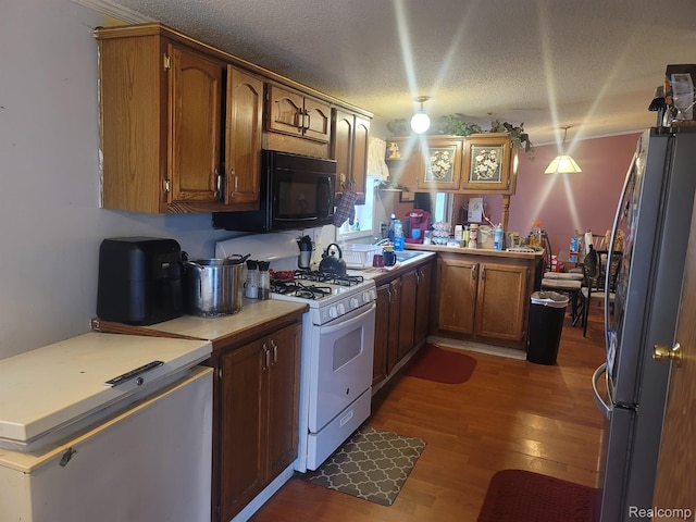 3092 Durant Hts, Grand Blanc, MI 48507 - kitchen featuring white range with gas cooktop, freestanding refrigerator, wood finished floors, a textured ceiling, and brown cabinets