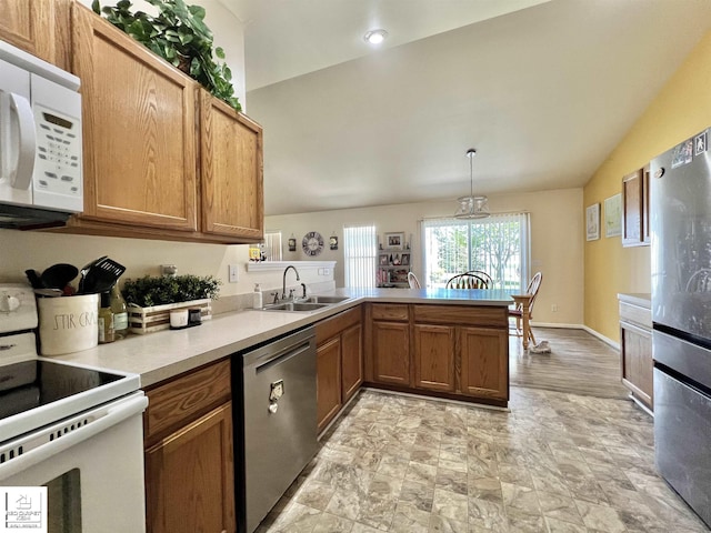 9304 Orchard Ct, Davison, MI 48423 - kitchen featuring appliances with stainless steel finishes, a sink, a peninsula, light countertops, and stone finish flooring