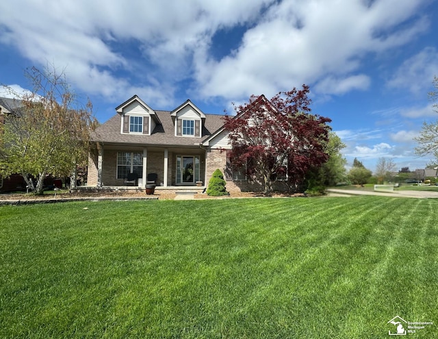25345 Hunter Ln, Flat Rock, MI 48134 - new england style home featuring brick siding, a front lawn, a porch, and a shingled roof